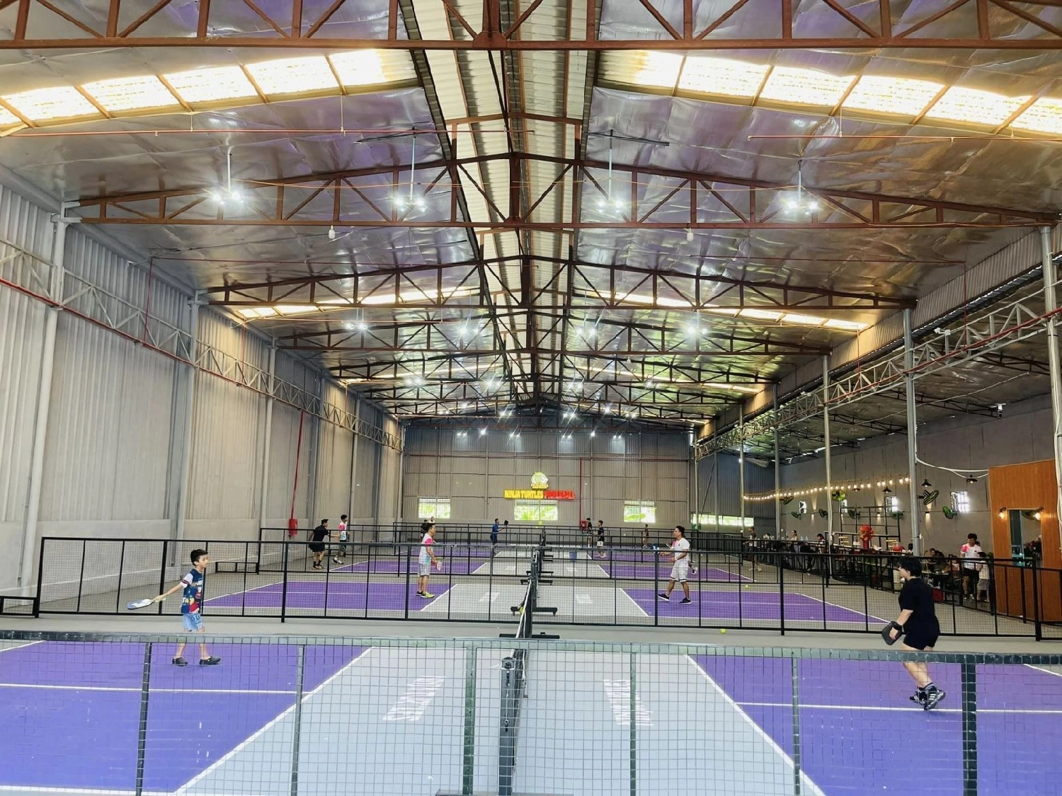 Indoor courts at Hyprground in Petaling Jaya featuring VIP lounges and view of playing area within the converted warehouse space.